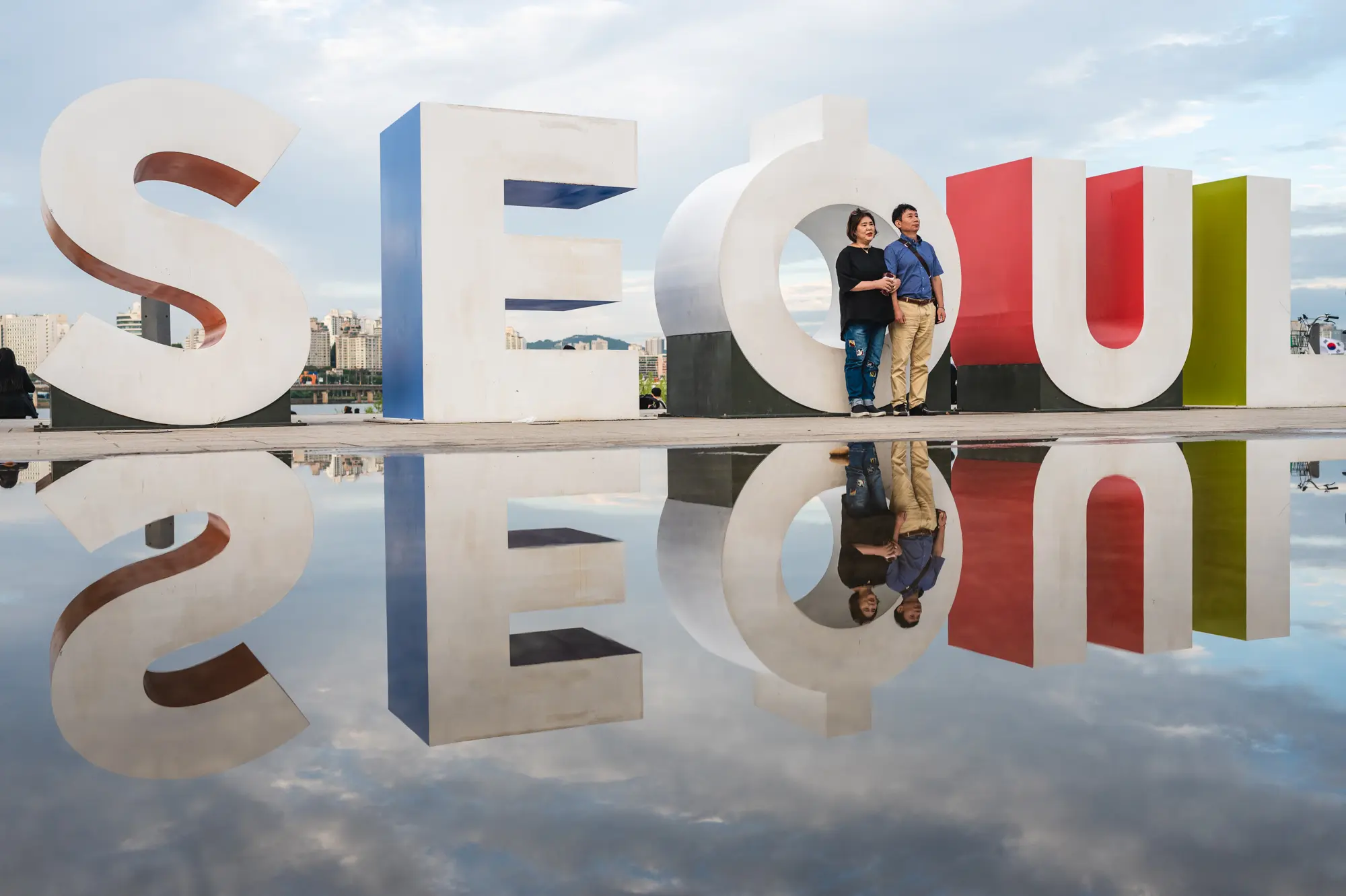 image of couple in front of Seoul logo